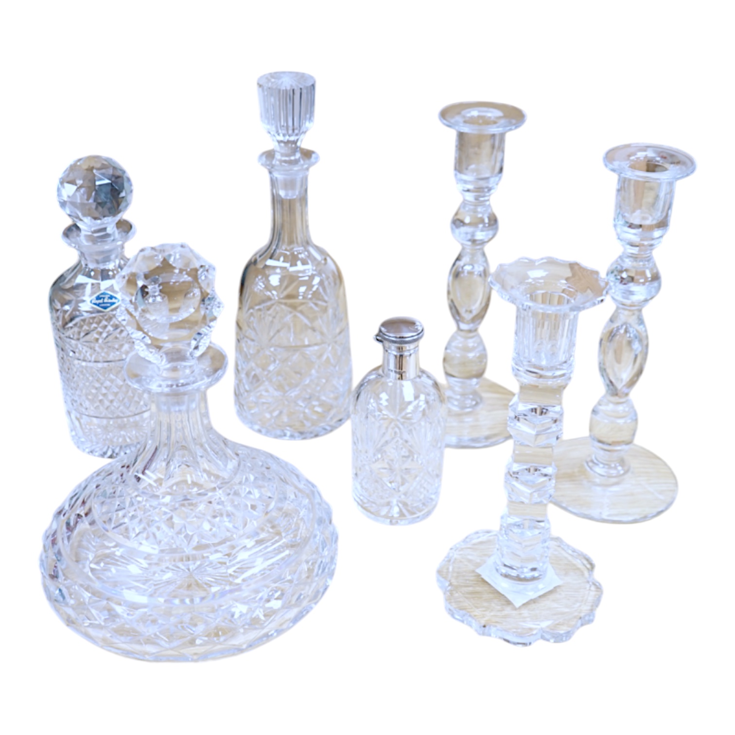 A cut glass ship’s decanter, two others and three various cut glass candle sticks, tallest decanter 30cm high. Condition - good